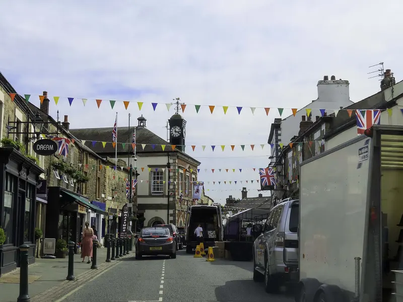 Garstang's High Street lined with stone shops and pubs, strung with bunting, leading to the small town hall with its clock turret