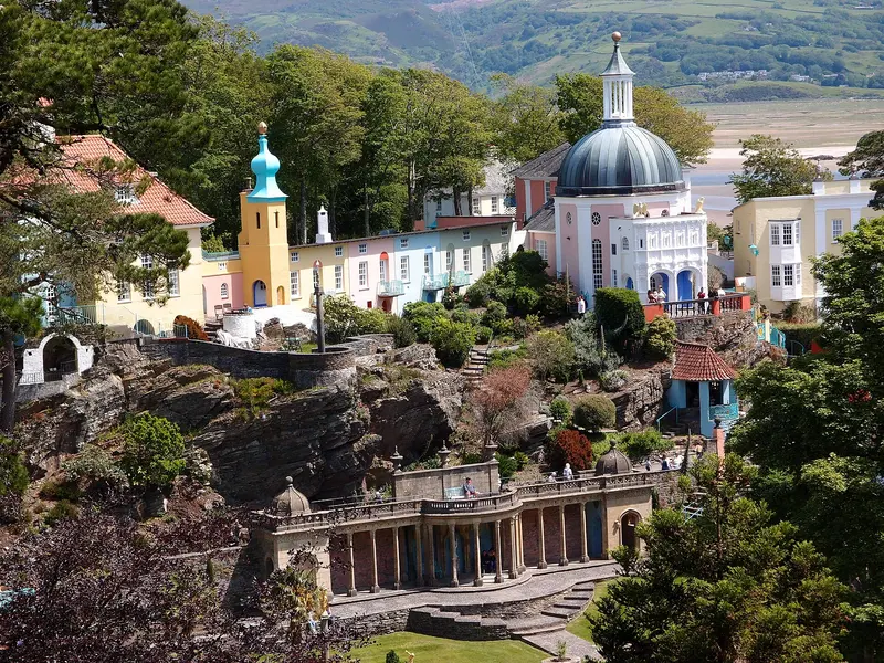 The colourful Italianate buildings of Portmeirion village, with a domed pavilion and towers, rising above rock gardens and a colonnade